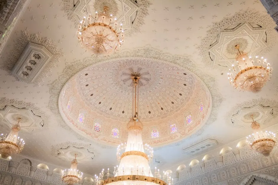 Stunning view of an ornate Islamic dome ceiling with grand chandeliers in Berlin.